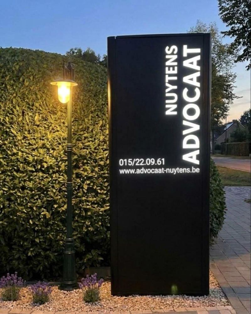 Verlichte zuil Nuytens Advocaat aan de L. Carréstraat in Hallaar